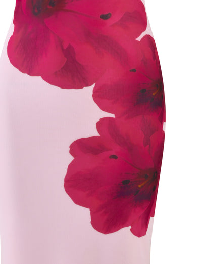 Close-up of the TIGERMIST LILLIAN DRESS - PINK : BABY PINK fabric, which features a white base adorned with large, vibrant red and pink floral prints. The flowers have dark centers and spread diagonally across the material, creating a striking contrast against the light background—making it perfect for a stylish midi-length dress.
