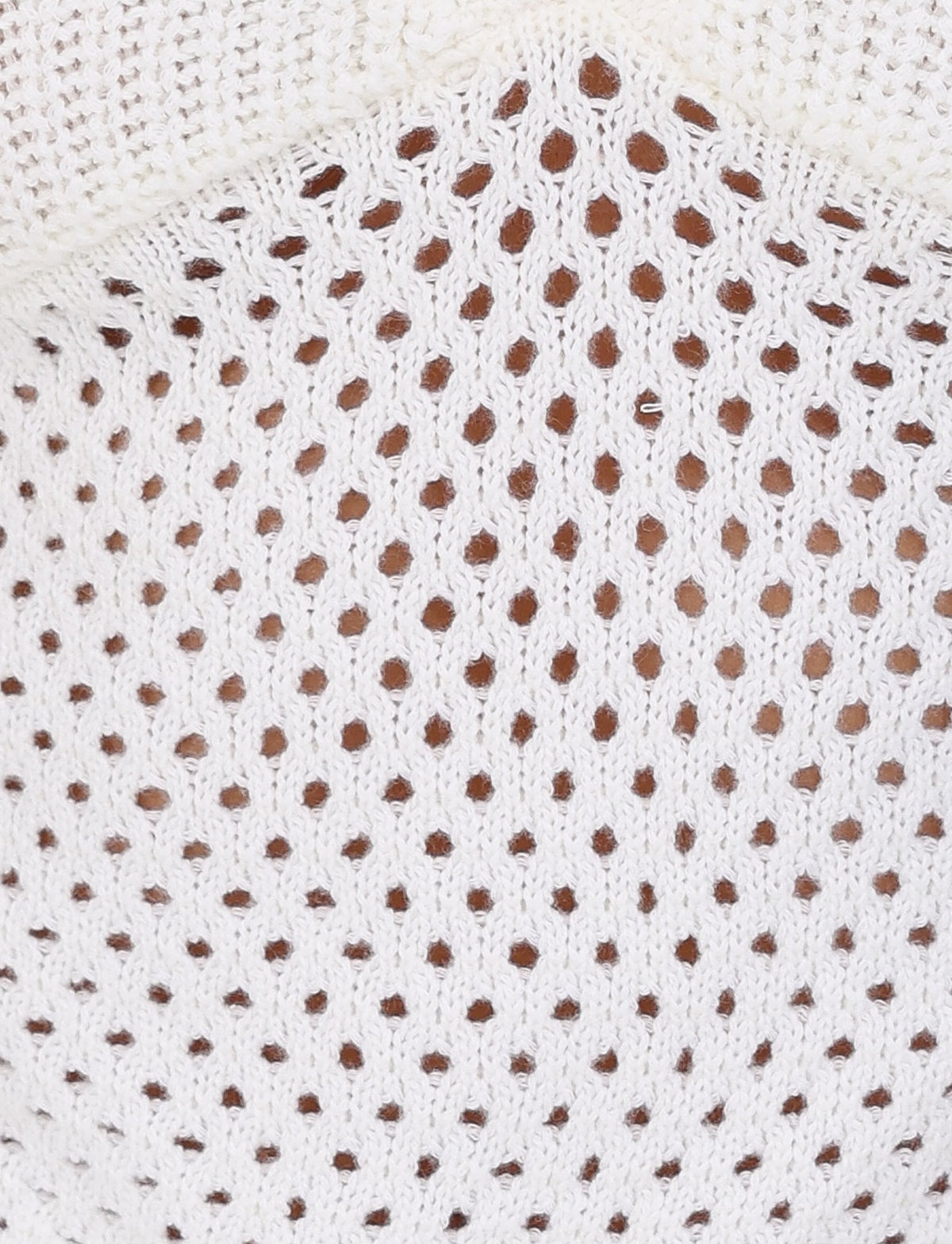 A close-up view of the Ramsey Top by Tigermist showcases a white, crochet-knit fabric with a mesh pattern and diamond-shaped holes. The crop-length design provides a soft, evenly spaced texture across its surface.