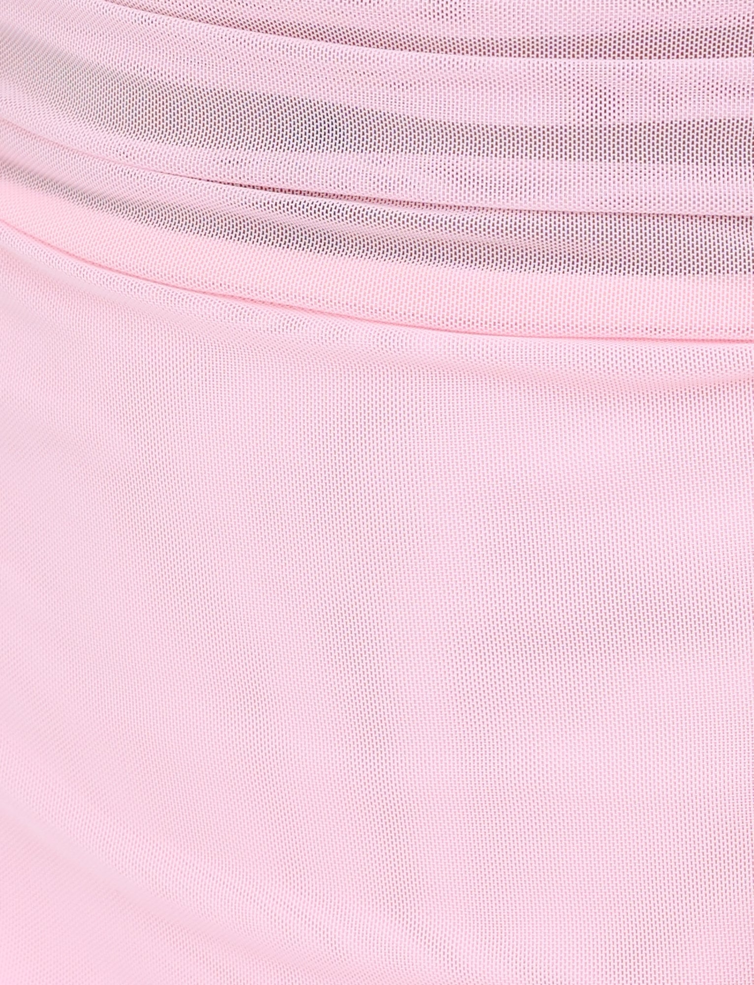 Close-up of the CARMELA DRESS in baby pink by TIGERMIST, featuring layers of soft pink tulle fabric that showcase delicate, translucent textures and gentle folds for a flowing appearance.