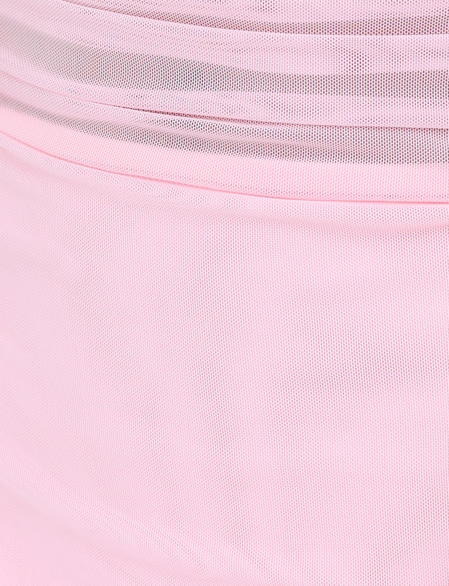 Close-up of the CARMELA DRESS in baby pink by TIGERMIST, featuring layers of soft pink tulle fabric that showcase delicate, translucent textures and gentle folds for a flowing appearance.
