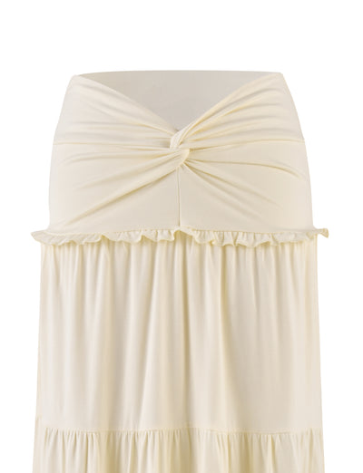 The TIGERMIST KATYA MAXI SKIRT in cream features a strapless design with a twisted knot at the top and tiered panels creating a ruffled seam below. The smooth, buttery jersey fabric is displayed against a plain white background.