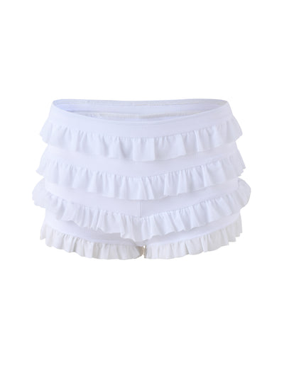 The MIKEL SHORT - WHITE by TIGERMIST showcases a playful and feminine design with multiple layers of ruffle details, creating a tiered and textured look. They feature an elasticated waistband and are displayed against a plain white background.