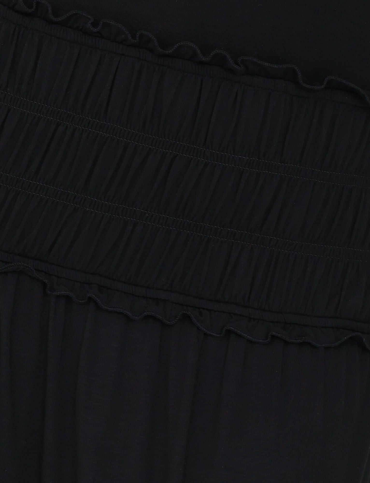 Close-up of the silky jersey material highlighting an elastic waistband complete with gathered detailing. The texture showcases two horizontal bands of ruching, giving it a layered look, reminiscent of the DENALI HALTER MAXI DRESS - BLACK by TIGERMIST's sophisticated design.