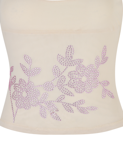 A close-up of the OCTAVIA TOP - NEUTRAL : CREAM by TIGERMIST shows cream fabric adorned with two floral and leaf designs made from small, shiny light purple rhinestones.