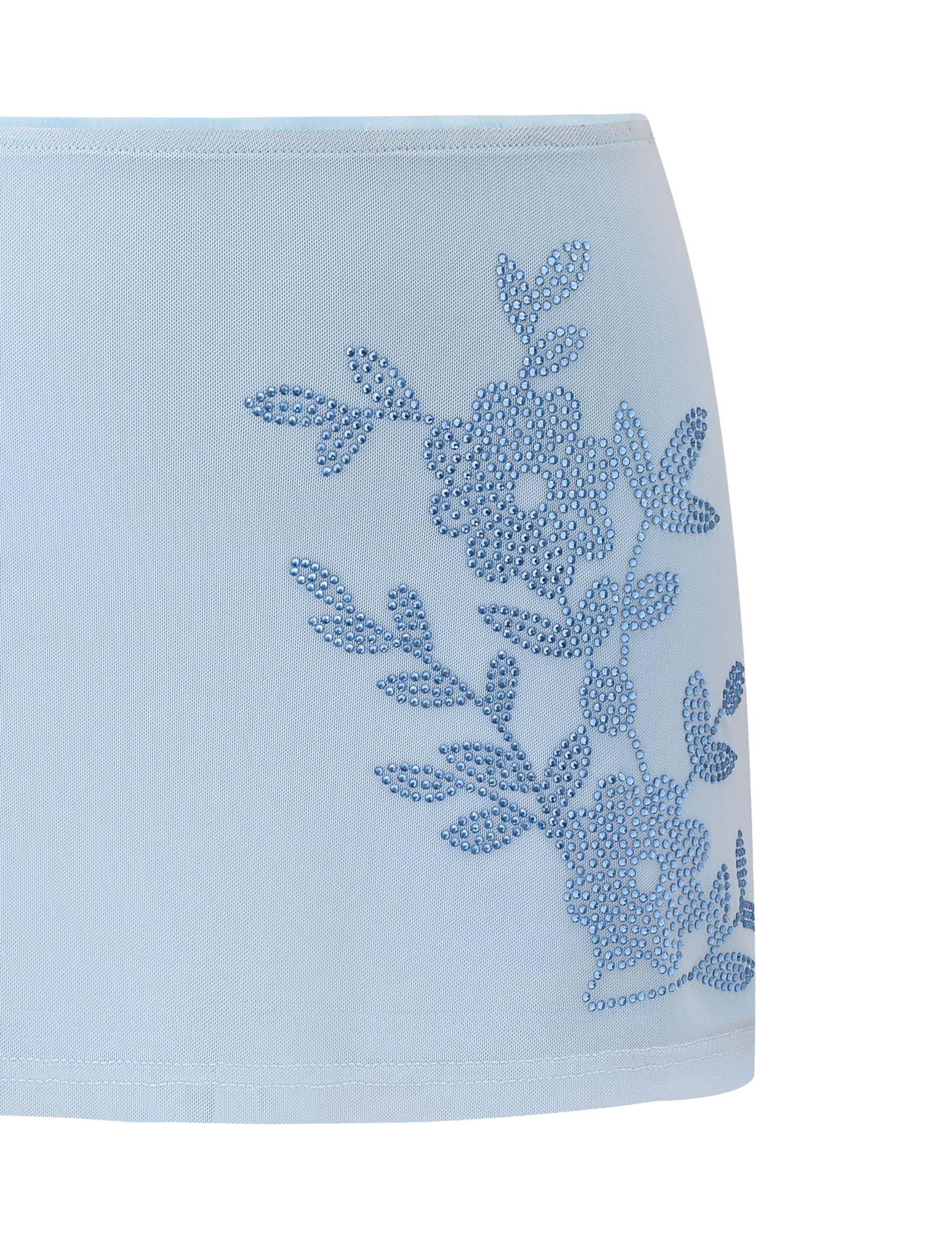 The OCTAVIA MINI SKIRT - BABY BLUE by TIGERMIST is a light blue mini skirt with a blue rhinestone floral embellishment on one side.
