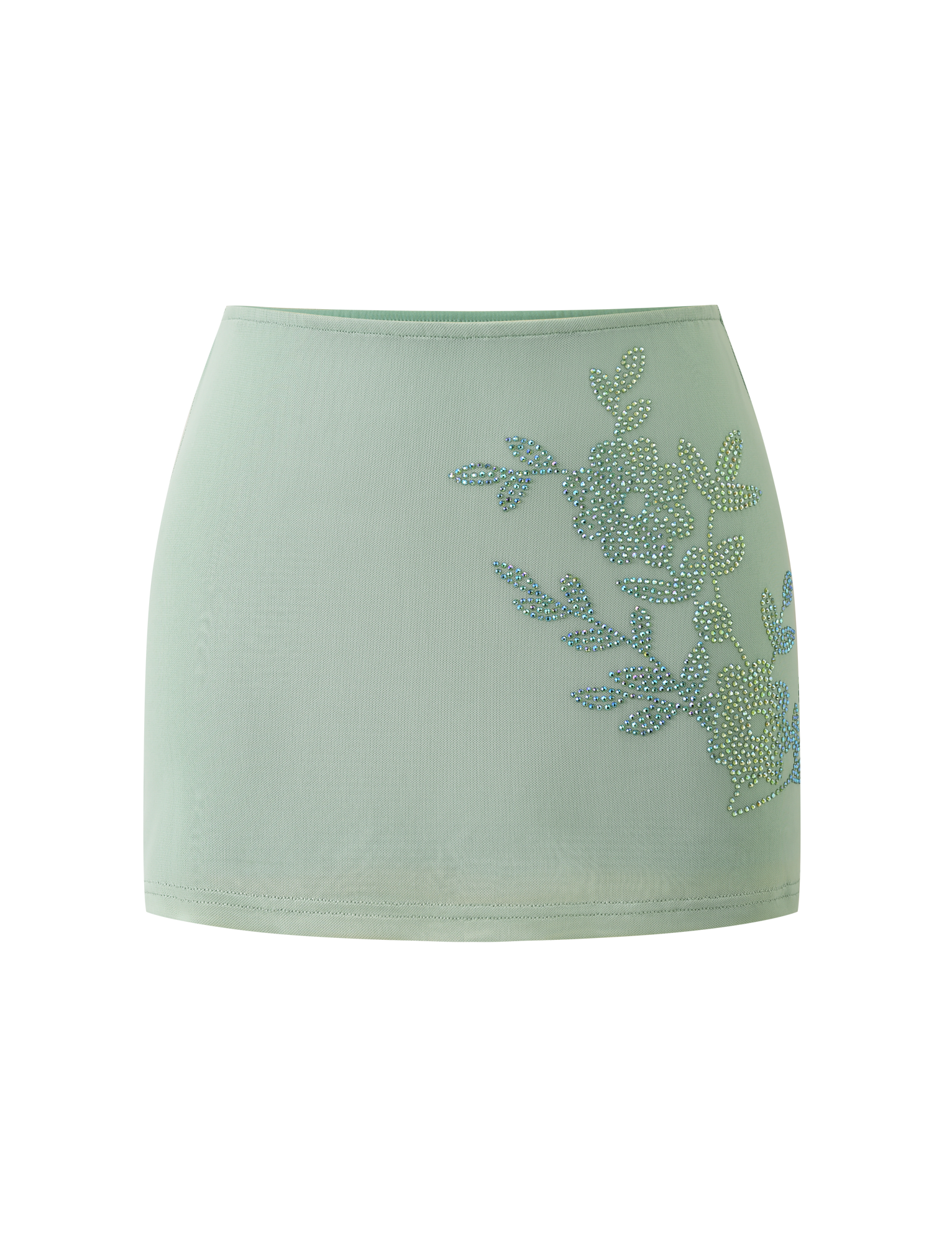 The TIGERMIST OCTAVIA MINI SKIRT in pistachio features a light green hue and rhinestone floral embellishment on one side, showcased against a plain white background.