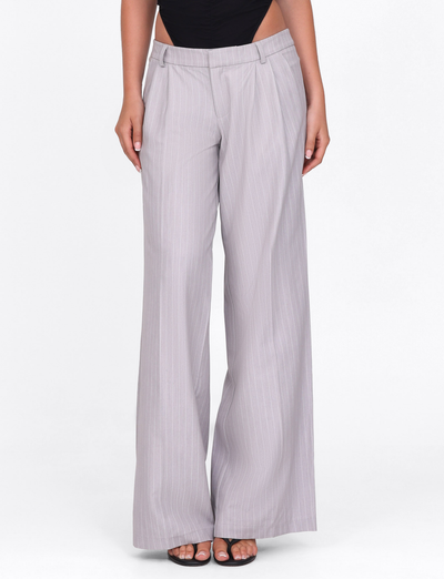 A model wears TIGERMIST's AMBERLY SUIT PANT in grey pinstripe, a high-waisted wide leg tailored pant, styled with black open-toed heels and a black top, shown from waist to feet on a plain white background.