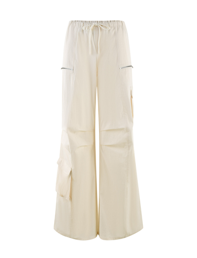 The TIGERMIST HERMIONE PANT in Soft Butter features a wide-leg, baggy cargo style with an elastic drawstring waist, zippered side pockets, and large leg flap pockets, showcased on a plain white background.