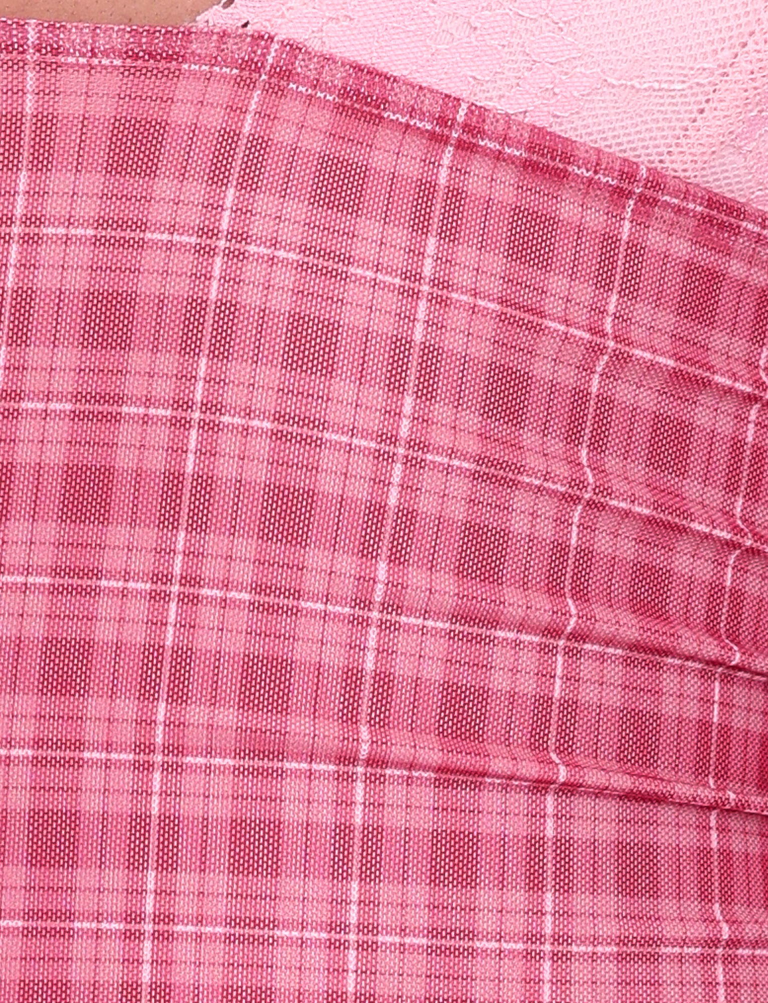 Close-up of the NAVIA DRESS - RED by TIGERMIST, featuring red check plaid fabric with pleats and a contrasting section with a subtle lace-like floral texture, both shown at an angle.