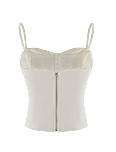 The TIGERMIST ANTONELLA TOP in white, bone, and cream features adjustable straps and a front zipper. Made from soft touch suiting fabric, it’s shown against a plain white background.