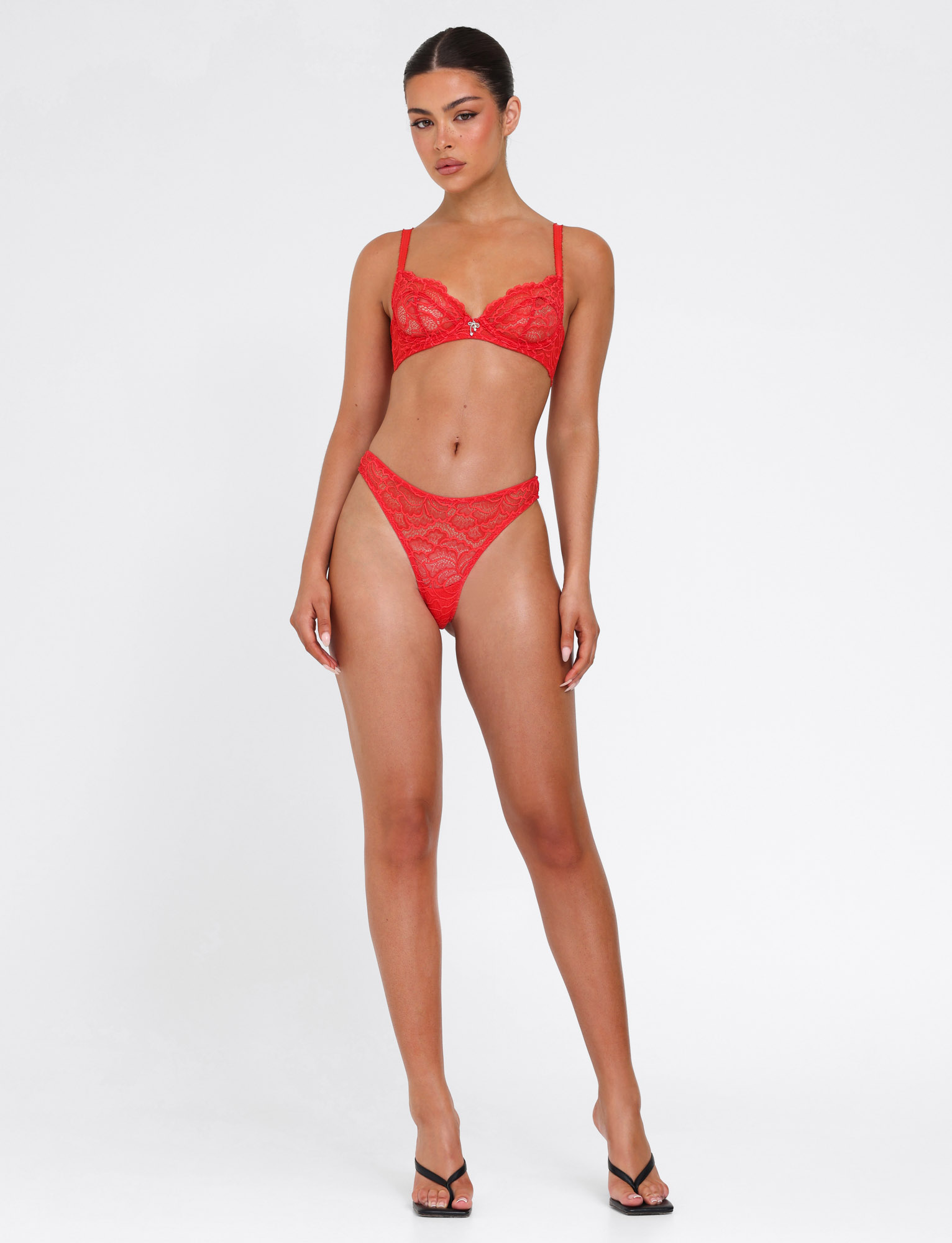 A woman faces forward with a neutral expression against a plain white background, wearing the TIGERMIST SIRENE SET 2.0 - RED lingerie set paired with black heels.