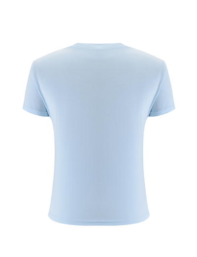 The SAPHIRA TEE - BLUE by TIGERMIST is a light blue, short-sleeve top shown from the back against a white background, featuring subtle blue rhinestones for a hint of sparkle in this classic design.