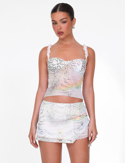 A woman wears the TIGERMIST JOSEPHINE TOP in white animal print with lace straps, paired with a matching mini skirt featuring lace trim, standing against a plain white background.