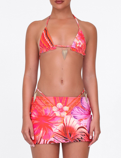 A woman models the TIGERMIST CIANA BIKINI 2PC BOTTOM in Pink Tropical—a vibrant floral swim set with a matching skirt, featuring pink, orange, and purple placement prints—against a plain white background.