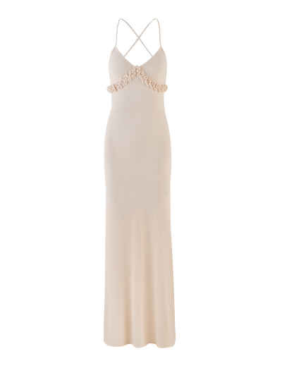 The TIGERMIST LAVELLE MAXI DRESS in Cream is a floor-length, sleeveless knit dress with thin criss cross straps, v-neckline, floral embellishments at the bust, open back, fitted bodice, and gently flared skirt for an elegant look.