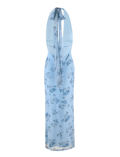The TIGERMIST PHAEDRA MAXI DRESS in blue floral features a light blue halter neck, fitted waist, scattered blue and white flower patterns, a long flowing silhouette, and an elegant back tie.