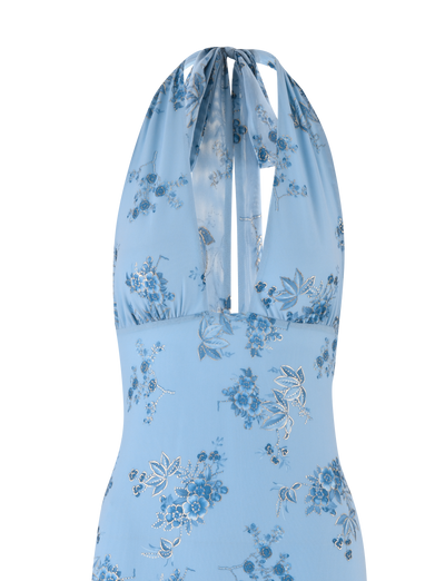 The PHAEDRA MAXI DRESS by TIGERMIST features a light blue halter neck with plunging neckline, blue floral pattern, and metallic foil accents for added shine.