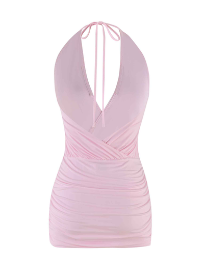The ANABELLE MINI DRESS in baby pink by TIGERMIST features a halter neck, deep V neckline, ruched sides, and a wrap-style waist. It’s shown against a plain white background.