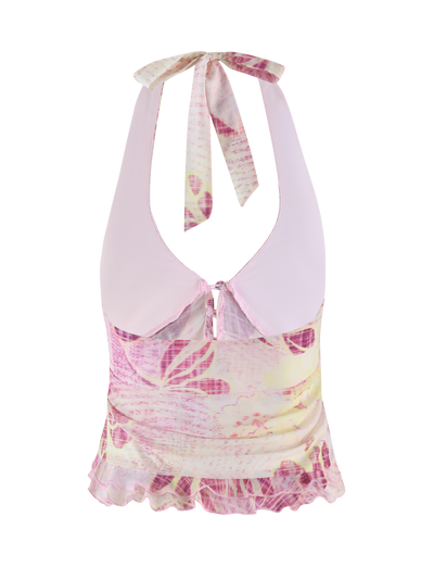 The DALILA TOP - GRUNGE FLORAL MAGENTA by TIGERMIST features a sleeveless halter design with a light pink collar, exclusive pink and yellow floral print, keyhole neckline with back ties, ruffled hem, and soft high-stretch semi-sheer fabric.