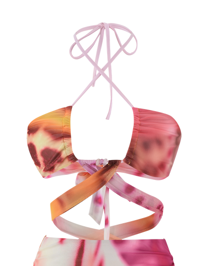 A close-up of the TIGERMIST ZARIAH MINI DRESS in MACRO ORCHID, featuring a vibrant pink, orange, and purple floral print with crisscross straps wrapping around the neck and torso.