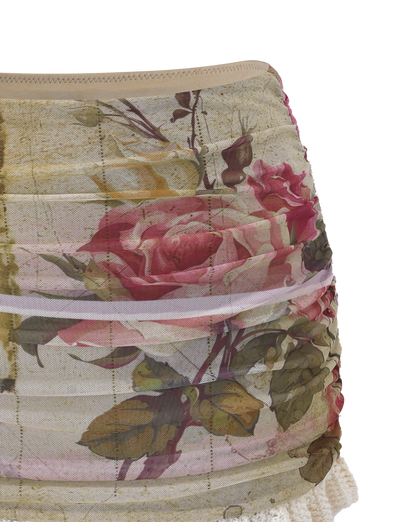 The TILLEY MINI SKIRT - ROSE POSTCARD by TIGERMIST features a vintage-inspired, semi-sheer floral mesh with a pink and red rose print, green leaves, and crochet ruffle lace trim at the hem.