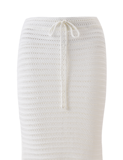The EMELYN MIDI SKIRT - CREAM by TIGERMIST is a white crochet midi skirt with a fitted silhouette, mid rise, and an elasticated waist with a drawstring tie.