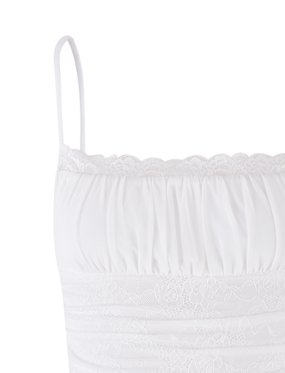 The AVALYN TOP - WHITE by TIGERMIST features thin spaghetti straps, a lace-trimmed neckline, ruched detailing, and a delicate lace band below the bust. Made from soft, lightweight stretch fabric for extra comfort.
