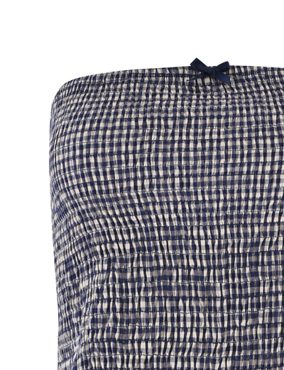 Close-up of the TIGERMIST ERYNN TOP - NAVY GINGHAM, featuring textured smocked navy and white checks and a small navy bow at the top center, accentuating this strapless top’s charming detail.