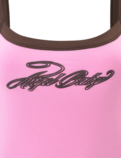 A close-up of the TIGERMIST MERRYN TANK - PINK, a graphic tank with brown trim and "Angel Baby" in black cursive, adding a playful touch to any outfit.