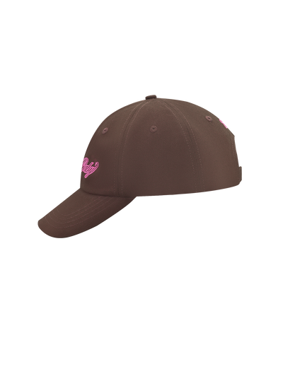 The TIGERMIST MERRYN CAP - CHOCOLATE, a brown 5 panel hat with pink embroidered front text, is displayed from a side angle against a plain white background.