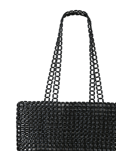 The LYNX BAG - BLACK by TIGERMIST is a large beaded tote with black beads in a grid-like open-weave design and two matching handles, shown against a plain white background.
