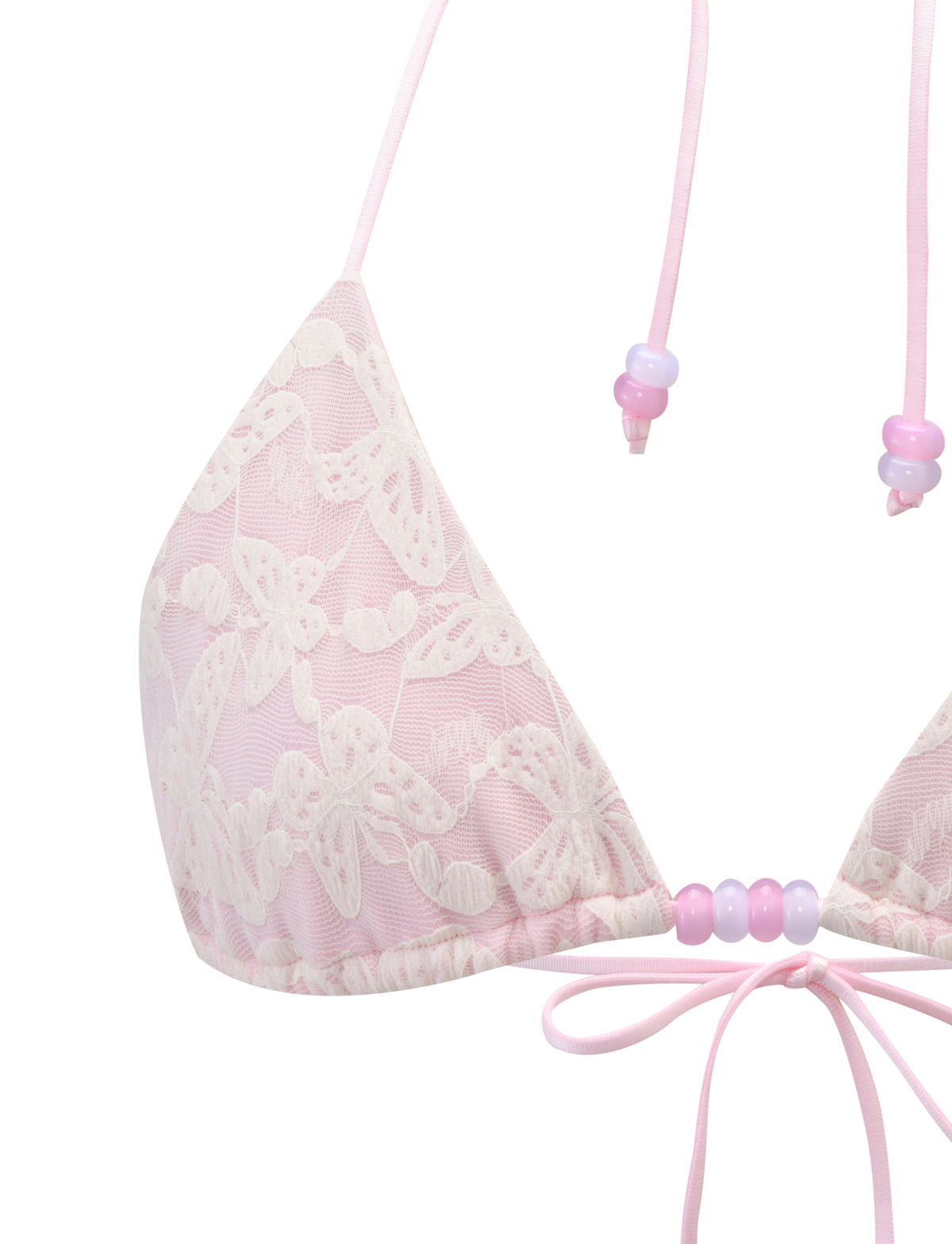 A close-up of the TIGERMIST BRIGITTE BIKINI TOP in ivory lace, featuring floral patterns, pastel beads on adjustable halter straps, and a small pink ribbon bow at the center.