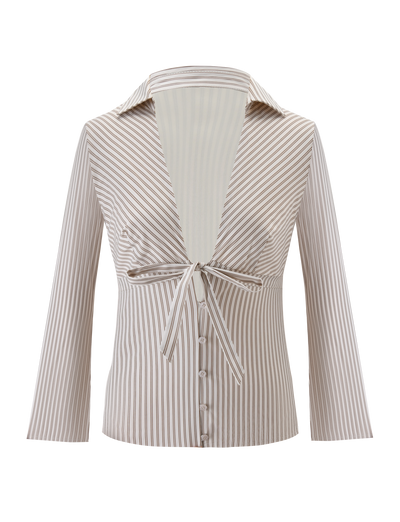 The SABRINE SHIRT by TIGERMIST is a women’s long-sleeve beige and white pinstripe shirt with a wide collar, deep V-neckline, tie-front detail, and button-down lower front.