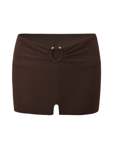 The LUNARA SHORT - CHOCOLATE by TIGERMIST features a gathered waistband, ruched front, small oval cutout, and two metallic stud accents.