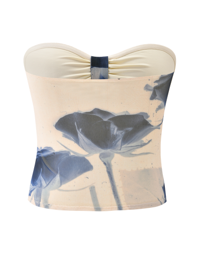 The JANIS TOP - INDIGO FLORAL by TIGERMIST is a strapless beige tube top with a center knot, bold blue rose print, and an artistic floral mesh design on the front.