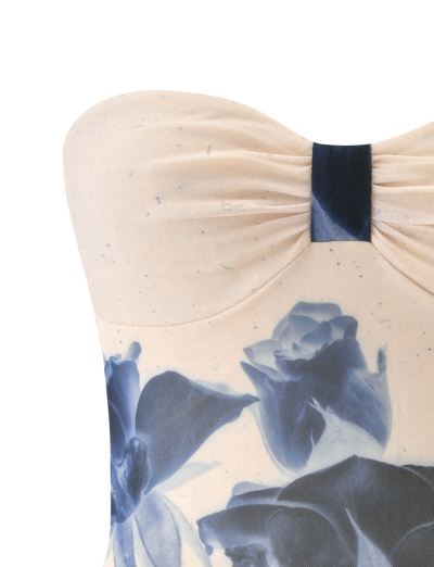 A close-up of the TIGERMIST JANIS TOP in indigo floral, a strapless cream tube top with blue rose print and a gathered, knotted center detail.
