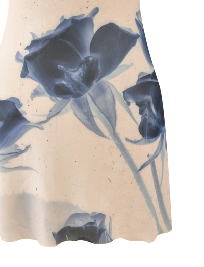 The TIGERMIST ROSY MINI DRESS - INDIGO FLORAL is a light mini dress with a vibrant blue rose print, featuring three prominent roses and a partially visible one near the bottom hem.