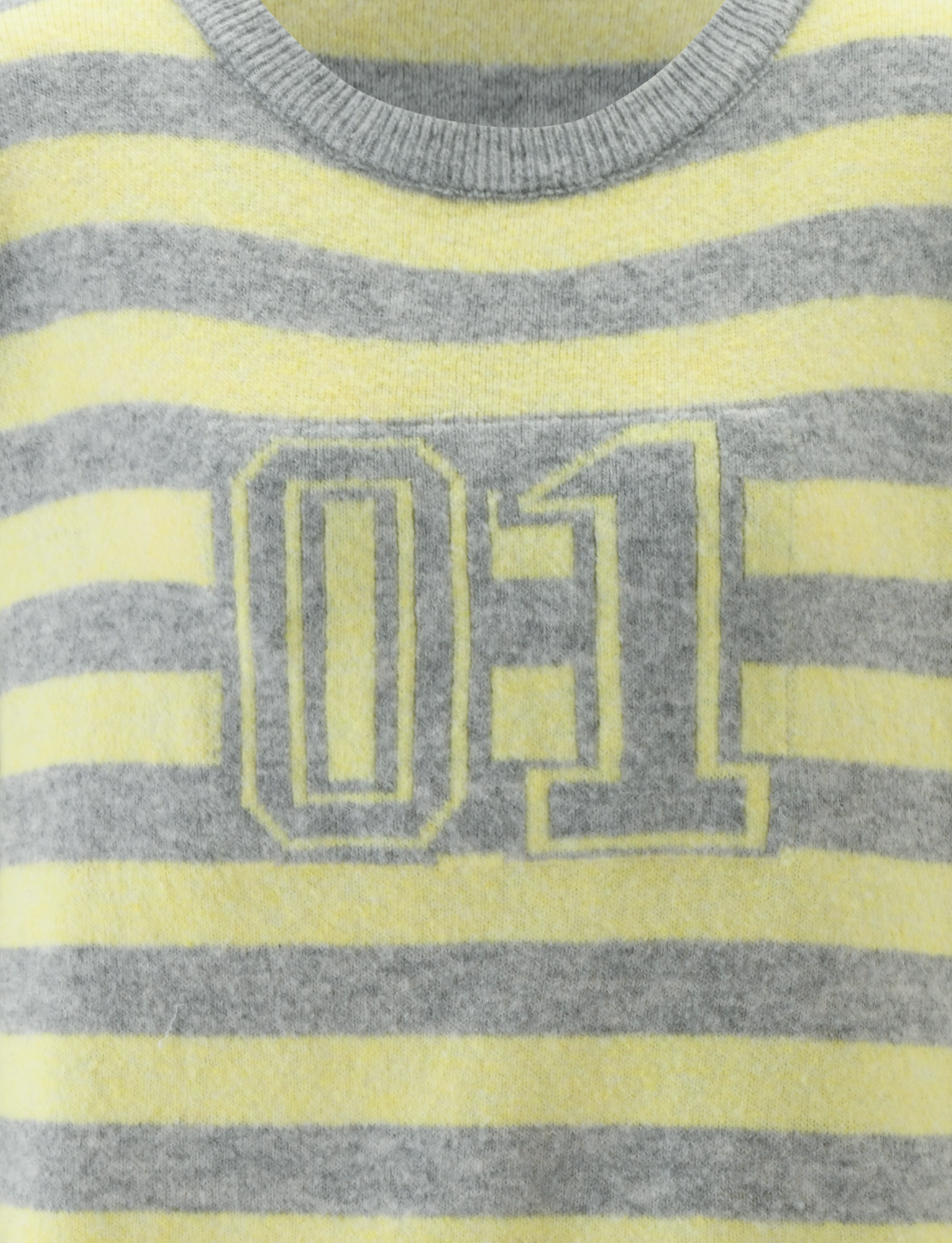 The KOA JUMPER by TIGERMIST is an oversized knit sweater with yellow and grey stripes and a sporty "01" design outlined in yellow on the chest.