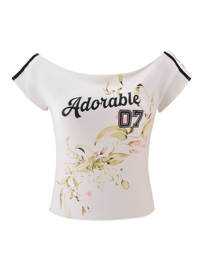 The FYNN TEE - WHITE by TIGERMIST is an off-shoulder baseball tee featuring "Adorable 07" in black and pink, plus light green and pink floral prints for a trendy floral graphic look.