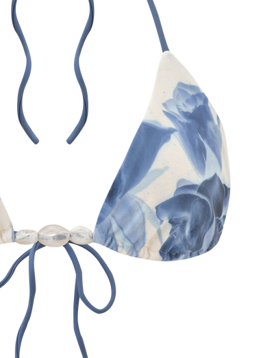 The TIGERMIST CYLAS BIKINI TOP in Indigo Floral features a halter neck, blue straps, blue and white floral design, and decorative translucent beads at the center.