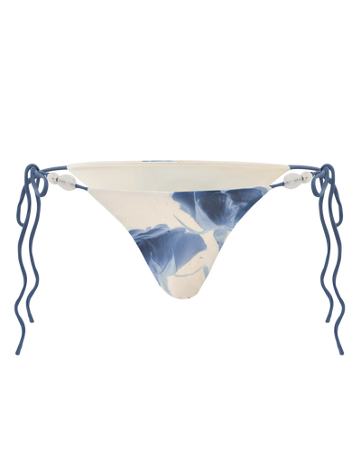 The TIGERMIST CYLAS BIKINI BOTTOM - INDIGO FLORAL features a blue and white marbled pattern with wavy blue side straps, offering a stylish update to classic florals. Shown against a white background.