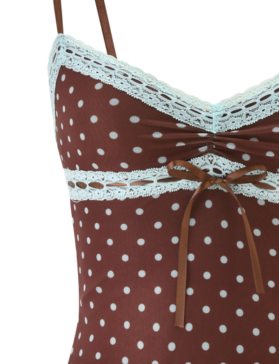 Close-up of the TIGERMIST AMARA TOP - POLKA DOT: a brown mesh cami with white polka dots, delicate lace trim at the neckline and underbust, plus a small brown ribbon bow below the bust.