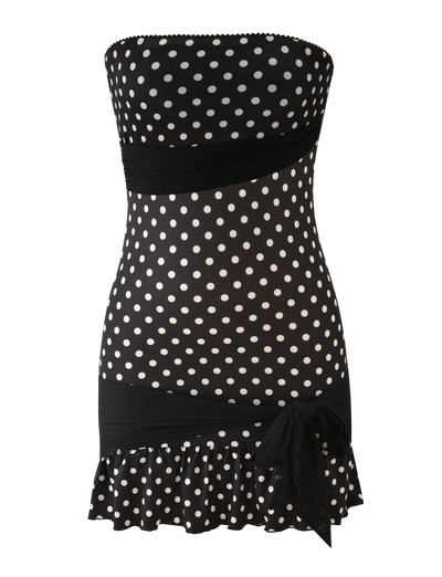 The TIGERMIST TOVE MINI DRESS in black polka dot features a strapless, bodycon fit with a fitted waist, wide sash and side bow, and is finished with a playful ruffle hem.