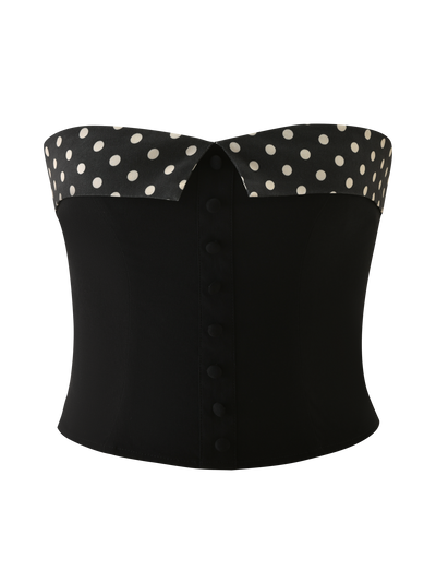 The KITTIE 2.0 BUSTIER by TIGERMIST is a black strapless suiting fabric corset top, featuring a folded-over collar with black and white polka dots and fabric-covered front buttons.