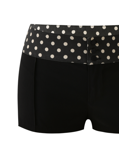 The TIGERMIST KITTIE 2.0 SHORT - BLACK features a fitted design, a wide polka dot waistband with large white dots, and three decorative black buttons on the front, made from soft Kittie fabric for a playful yet chic look.