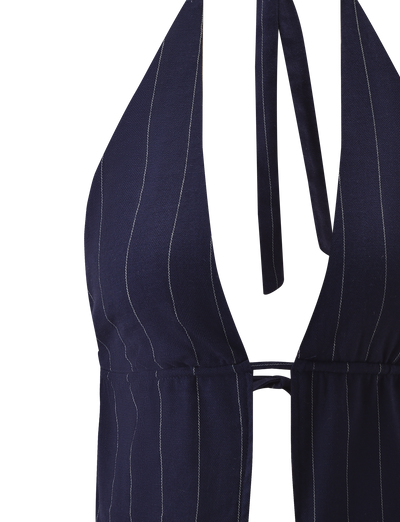 Close-up of the TIGERMIST LAINEY TOP - NAVY PINSTRIPE, showcasing an adjustable halter neck tie and deep V-neckline with thin white vertical pinstripes.