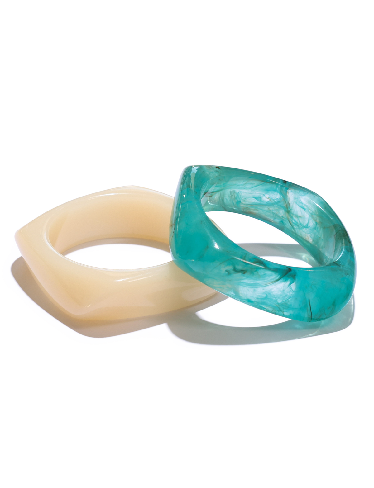 The TIA CHUNKY 2PC RESIN BANGLE SET by TIGERMIST features two square resin bangles—one solid cream and one marbled blue—styled overlapping on a white background.