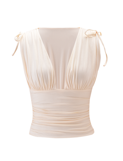 The HALONA TOP - CREAM by TIGERMIST features a sleeveless design, deep V-neckline, gathered bust, wide waistband, and adjustable shoulder ties for a custom fit, shown against a plain white background.