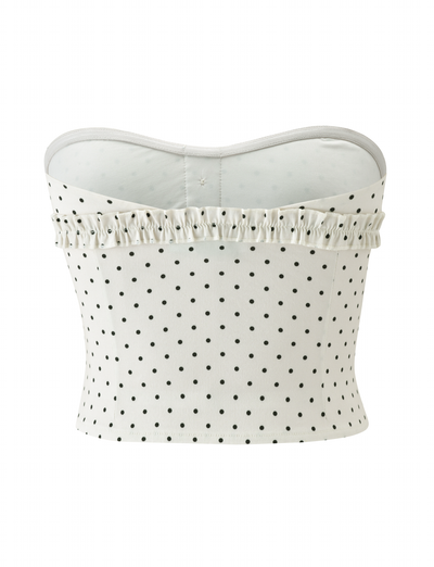 The KITTIE STRAPLESS CORSET - CREAM DOT by TIGERMIST features a white strapless design with black polka dots and a ruffled trim for a playful, feminine look.