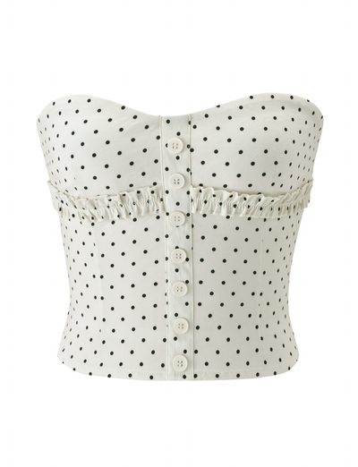 The KITTIE STRAPLESS CORSET - CREAM DOT by TIGERMIST features a strapless design, cream polka dot pattern, sweetheart neckline, white buttons down the front, and ruffled trim detailing across the chest.